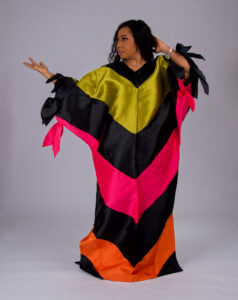 Model wearing The Kaleidoscope color-block boubou in black, yellow, pink and orange