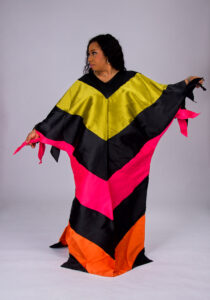 Model wearing The Kaleidoscope color-block boubou in black, yellow, green and orange