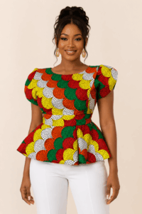 Model wearing The Zuri Radiance Ankara Peplum Blouse with white trousers
